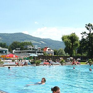 Mehrere Menschen schwimmen im Becken des Volksgartenbades.