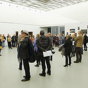 Foto von vielen Menschen bei der Ausstellungseröffnung in einem großen Raum