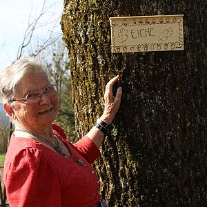 Irma Bucher vor einem Baumschild
