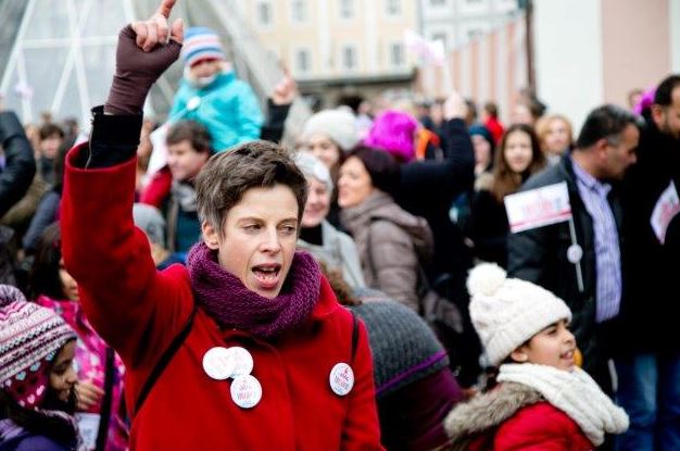 Demostration in Salzburg mit einer Frau um Vordergrund.