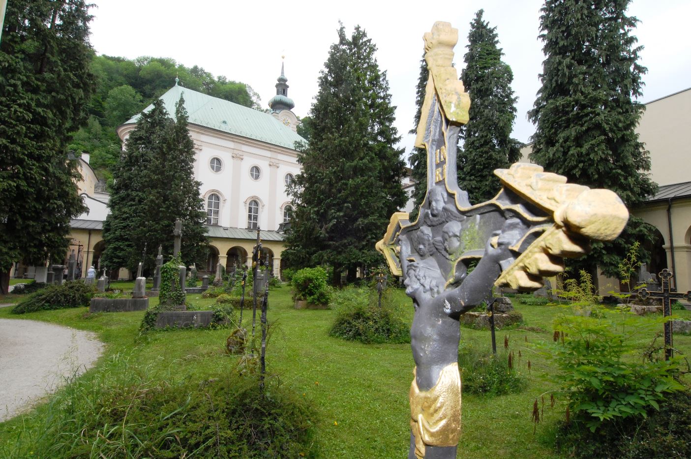 Sankt Sebastian mit Friedhof umgeben von vielen großen Bäumen.