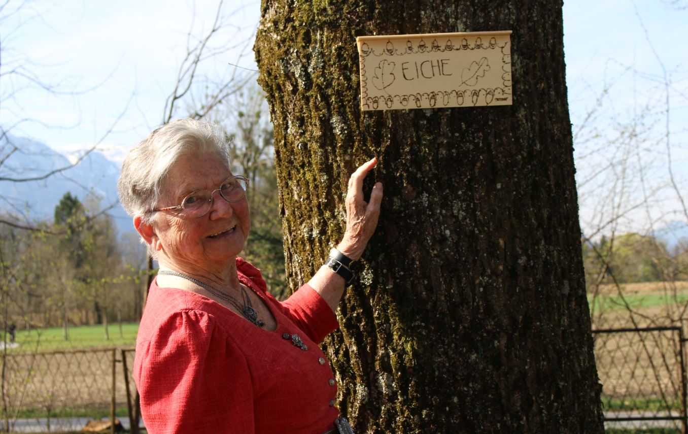 Irma Bucher vor einem Baumschild