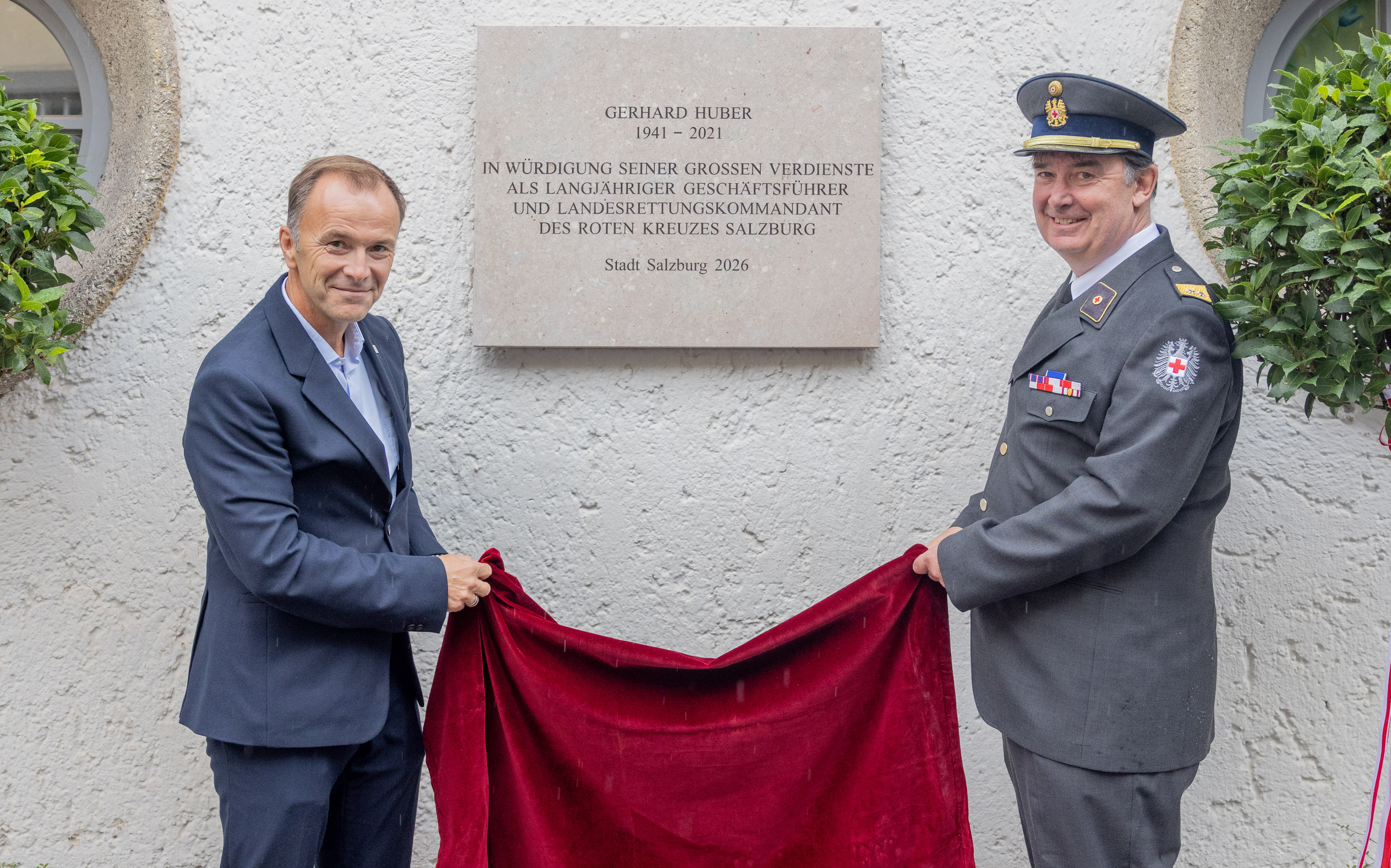 Bürgermeister und Sohn enthüllen marmortafel an Gebäude für Gerhard Huber