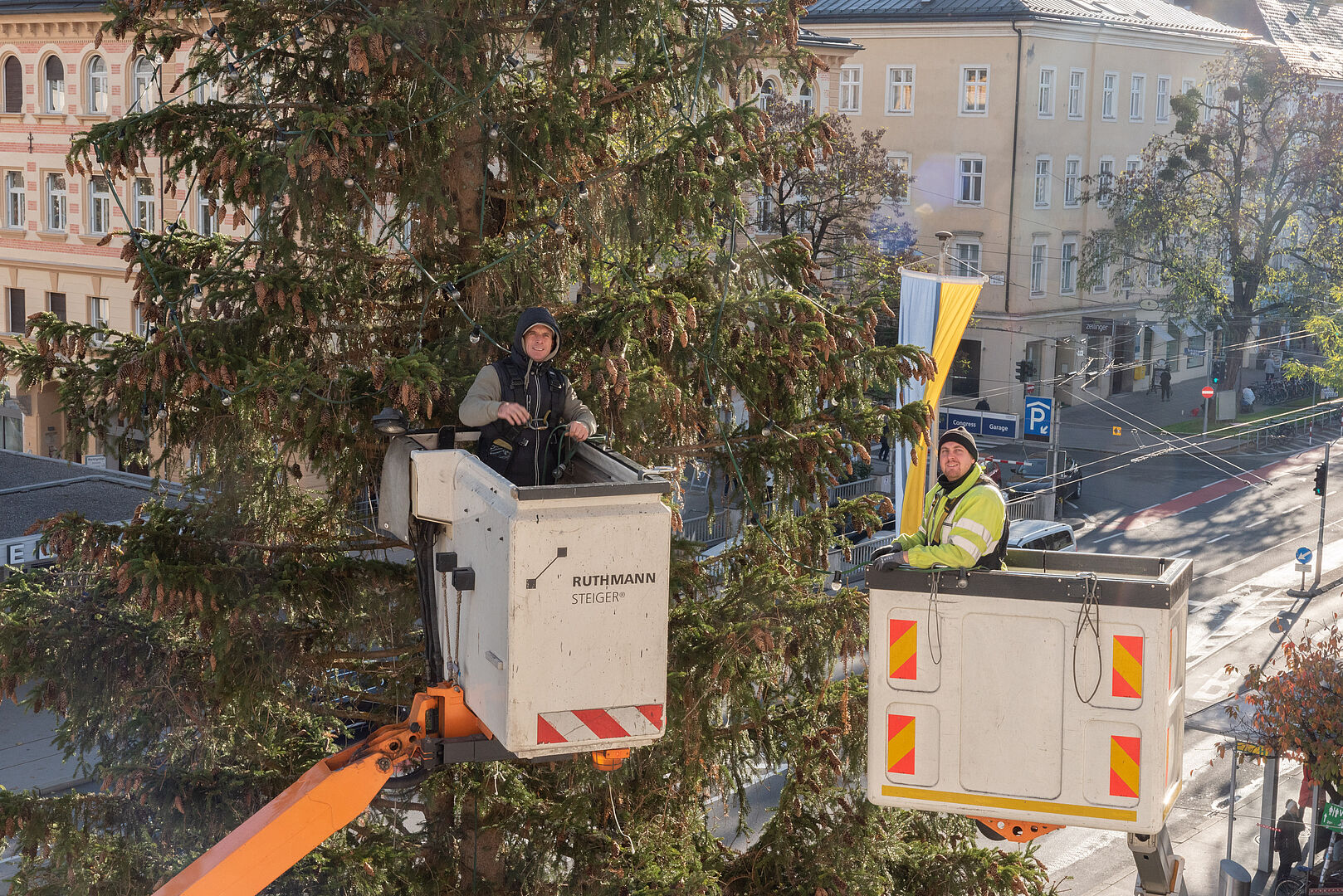 Mitarbeiter der städtischen Beleuchtung schmücken den Weihnachtsbaum mit Lichterketten